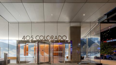 Photo of entrance of glass office building on ground floor, with "405 Colorado" in letters above the door.