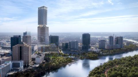 A very tall, three-sectioned tower with a bunch of other tall towers nearby and a river on the left.