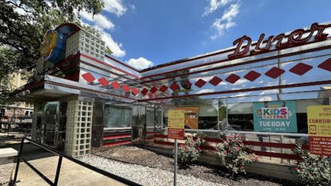 Photo of a Denny's diner exterior with Art Deco letters reading "Diner" and parking signs.
