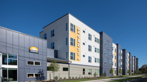 Rendering of new no-frills four-story apartment building with smaller building attached and sign that reads "Loretta."