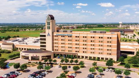 Rendering of a wide six-story hospital facility with a small bell tower in the center.